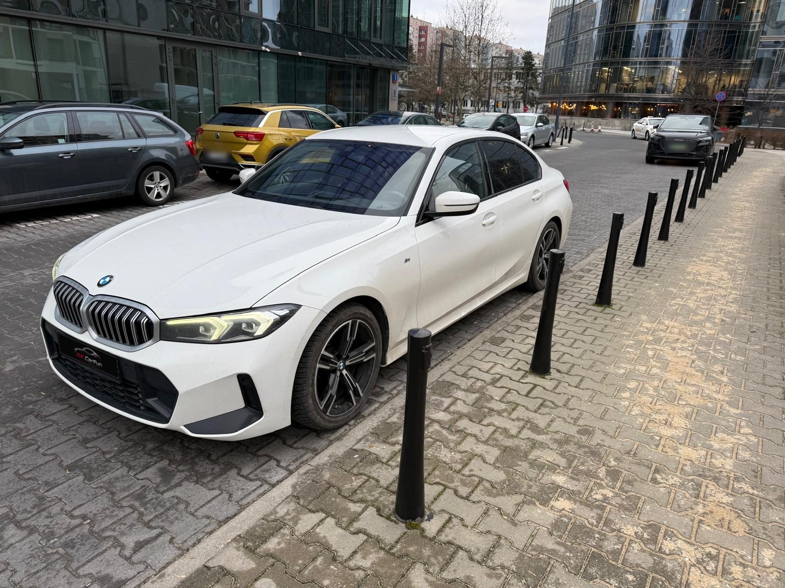 BMW 318i G20 2023 z przodu, na ulicy z zaparkowanymi autami